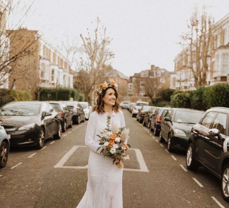 Bride wearing mid-length vintage dress with nude heels and floral crown