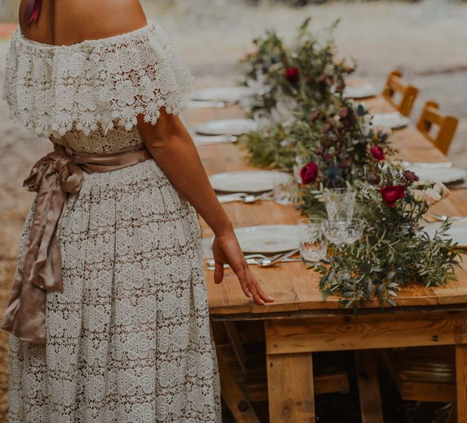 Bride in Lace Wedding Dress Standing at the Rustic Tablescape