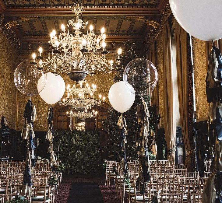 Wedding Ceremony Room at Carlton Towers in Yorkshire with Giant Balloons and Tissue Tassels, Christmas Tree and Foliage Wall Backdrop