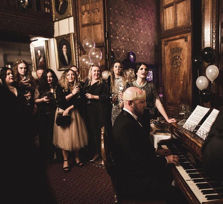 Wedding Guests Enjoying a Sing Song at The Piano