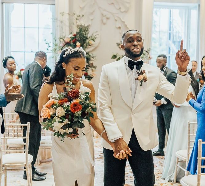 Stylish bride and groom descending up the aisle as husband and wife