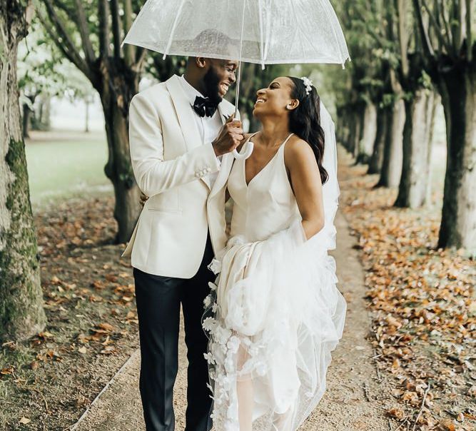 Bride and groom portrait under an umbrella at Coworth Park