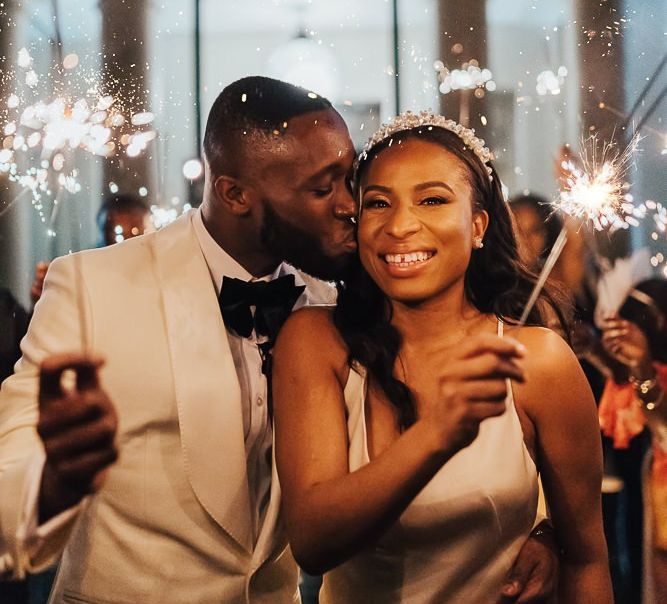 Groom kissing his bride during sparkler exit