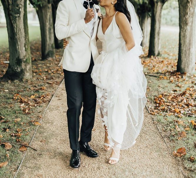 Bride and groom kissing under an umbrella at Coworth Park wedding