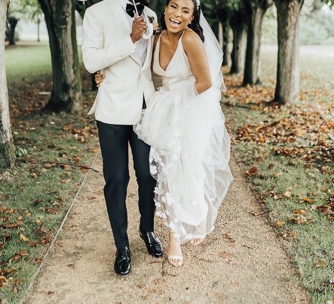 Stylish bride and groom laughing under an umbrella Autumn wedding