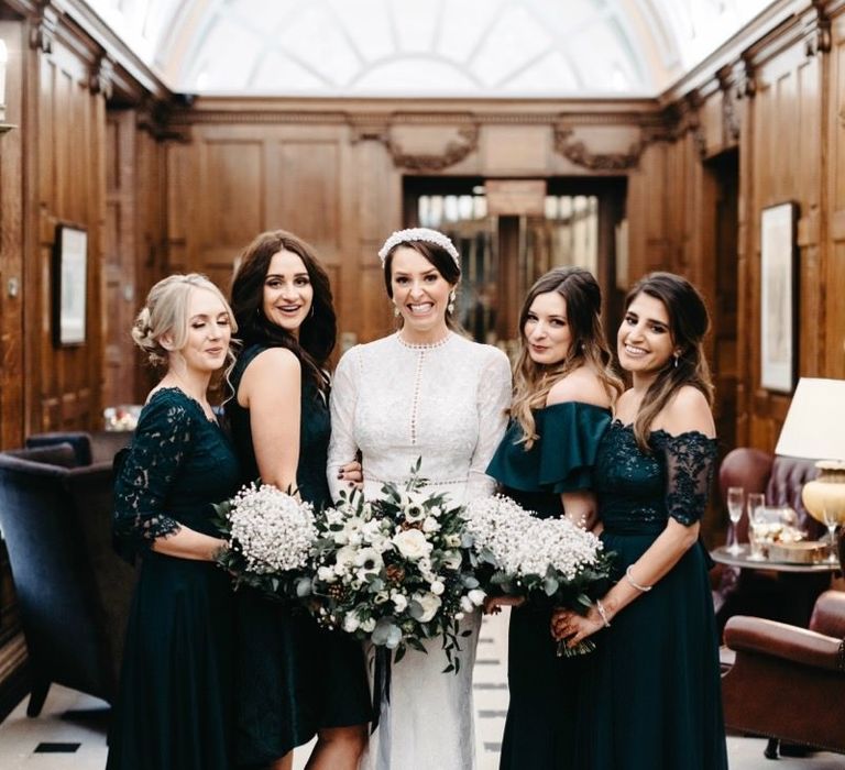 Bride wearing embellished headband and her bridesmaids in green dresses with gypsophila bouquets