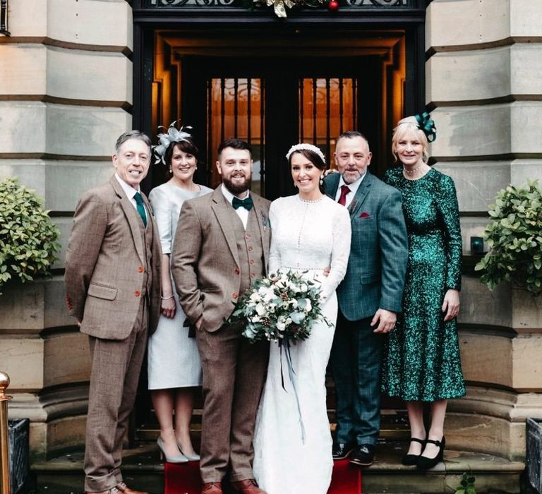 Groom wearing tweed wedding suit and bride wearing beautiful long sleeved dress