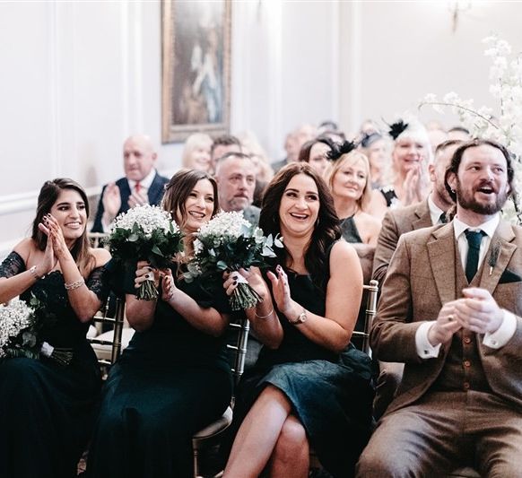 Bridesmaids wearing green dresses and gypsophila bouquets at the ceremony