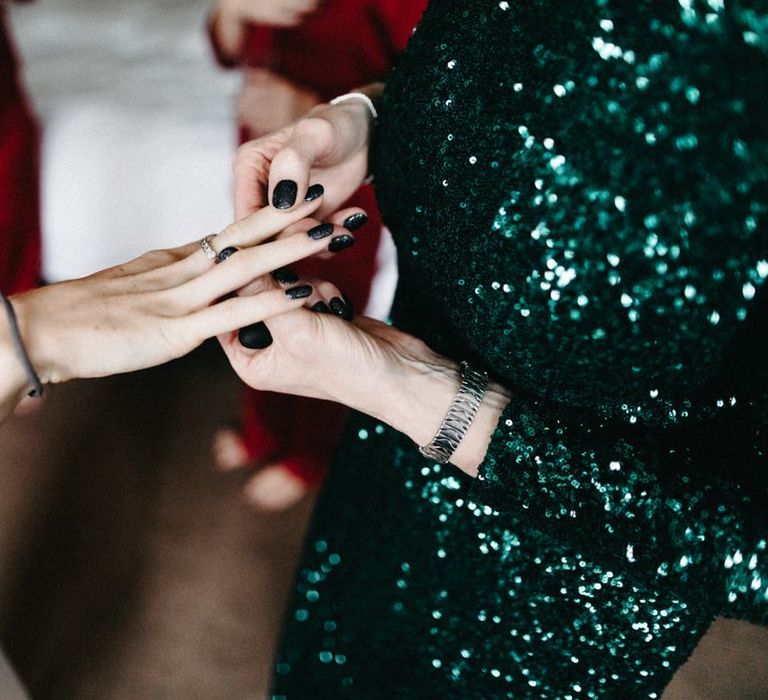 Black glitter nail varnish and green sequin dress at Christmas celebration