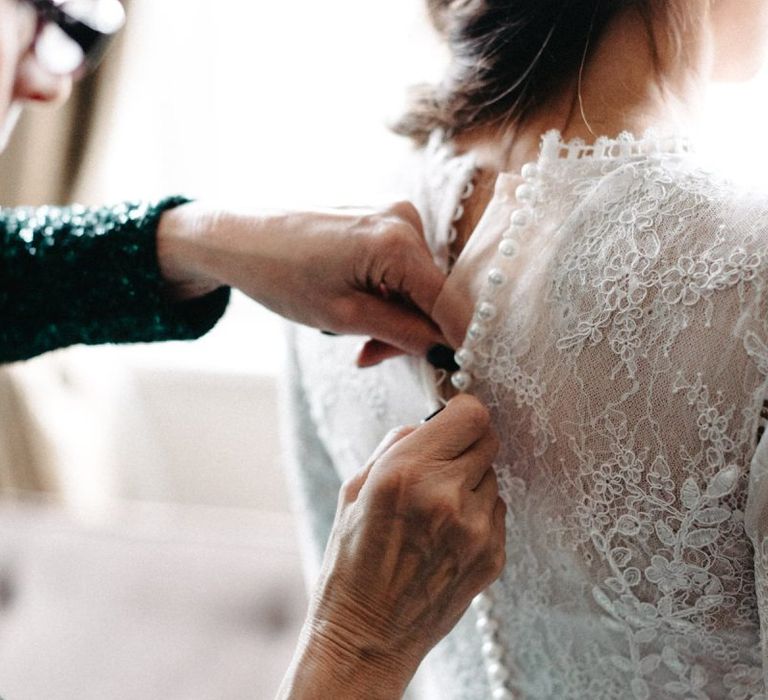 Back of brides beautifully laced dress with button detailing