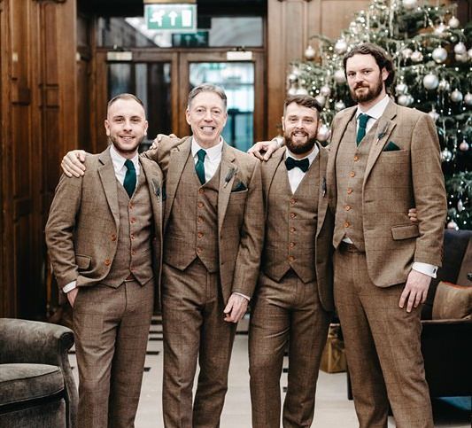 Groom and his groomsmen wearing tweed wedding suit with green ties and pocket squares