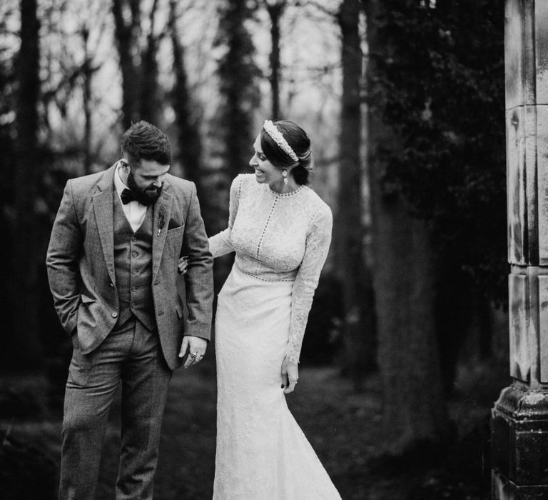 Bride and groom steal a moment at Christmas celebration wearing tweed wedding suit