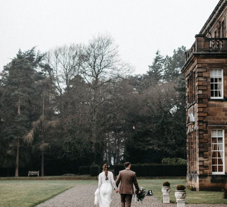 Beautiful winter celebration at country house with tweed wedding suit