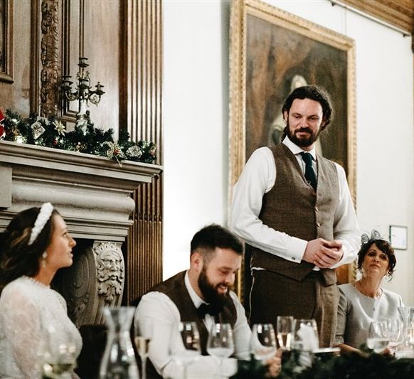 The speeches begin at Christmas wedding with foliage decor