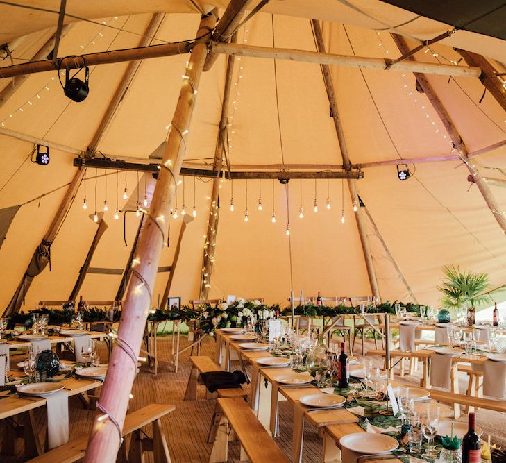 Rustic Tipi Decor with Trestle Tables &amp; Edison Light Installation | Outdoor Wedding Ceremony &amp; Tipi Reception Planned by Benessamy Events | Red on Blonde Photography