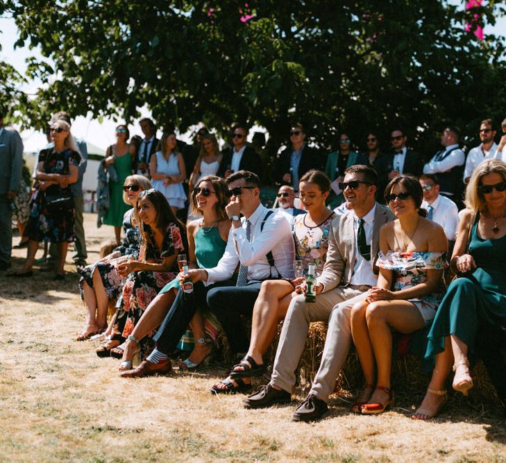 Wedding Guests Sitting on Hay Bales at Outdoor Wedding Ceremony