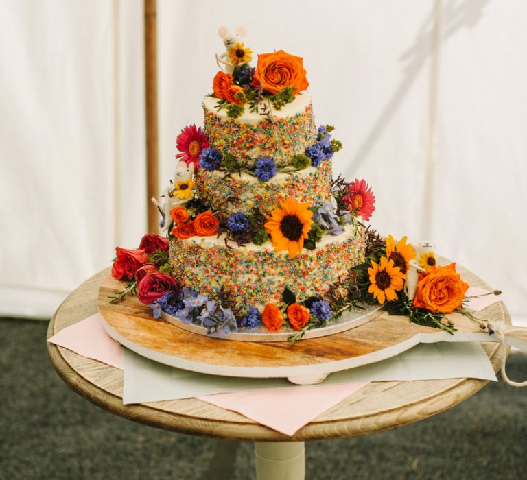 Wedding Cake Covered in Colourful Sprinkles and Flowers