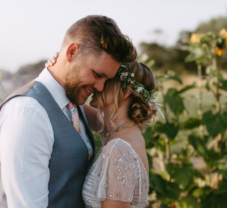 Bride in Jenny Packham Portia Wedding Dress and Flower Crown and Groom in Ted Baker Suit  Embracing in a Sunflower Field