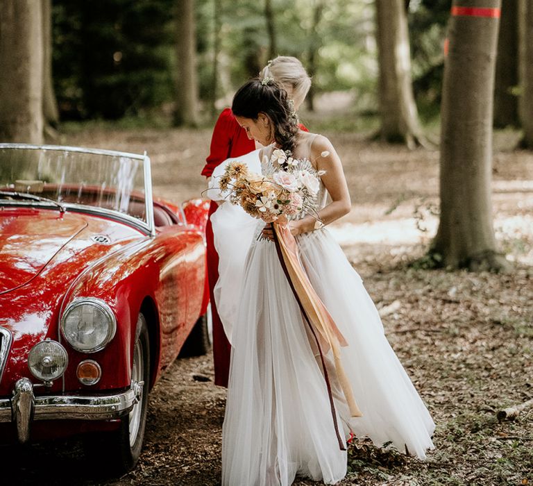 Bride in Valentini wedding dress arriving by vintage wedding car