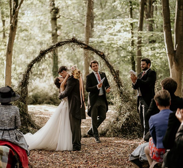 Bride and groom embracing at Evenley Wood Garden wedding ceremony