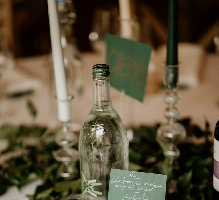 Green wedding stationery on the reception tables