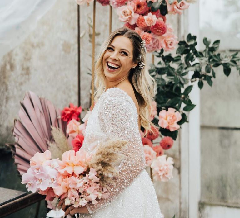 Laughing bride holding her pink bouquet