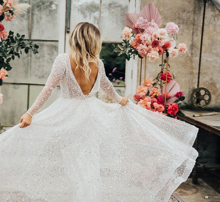 Bride in sparkling wedding dress twirling