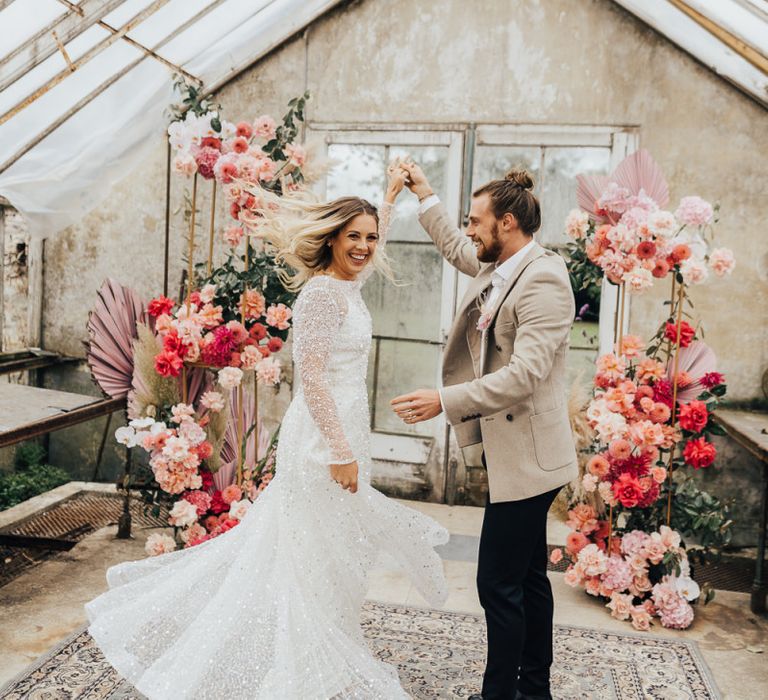 Groom twirling his bride in a Sparkly dress