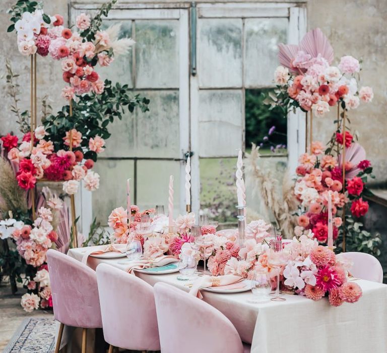 tablescape styling with velvet chairs, floral table runner and linens in pink colour scheme