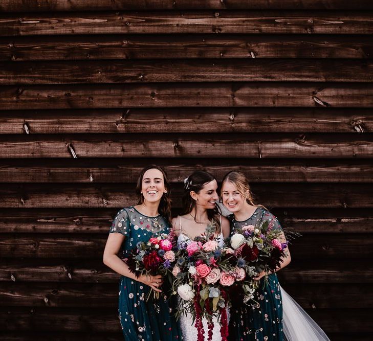 Bride With Bridesmaids In Floral Dresses And Pink Flower Bouquets