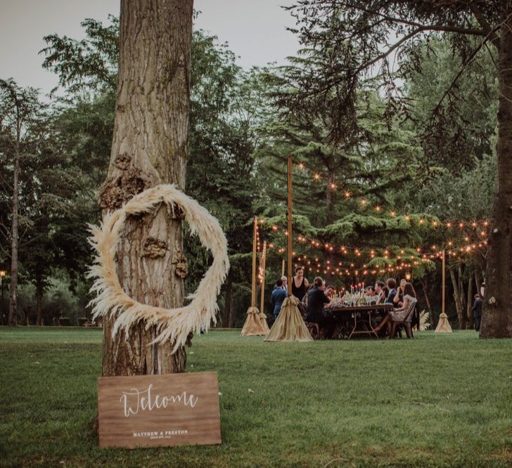 Pampas Grass Hoops &amp; Wooden Welcome Sign Wedding Decor | Outdoor Woodland Wedding at Sa Farinera de Sant LLuis Wedding Venue, Catalan Empordà, Spain | Planned &amp; Styled by Mille Papillons | HUMà06 Photography | HUMà06 Photography