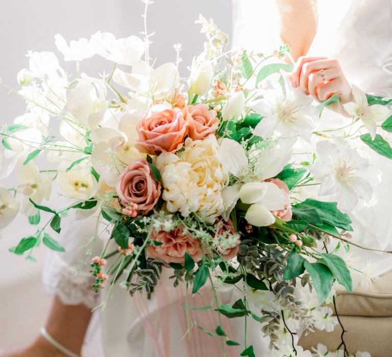 Romantic peach and cream wedding bouquet with roses and tulips