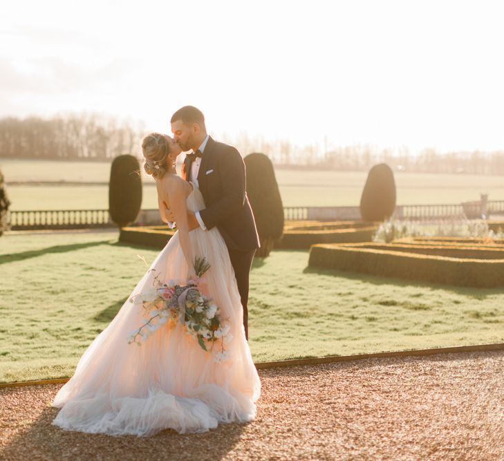 Golden Hour portrait with bride in tulle wedding dress and groom in black tie