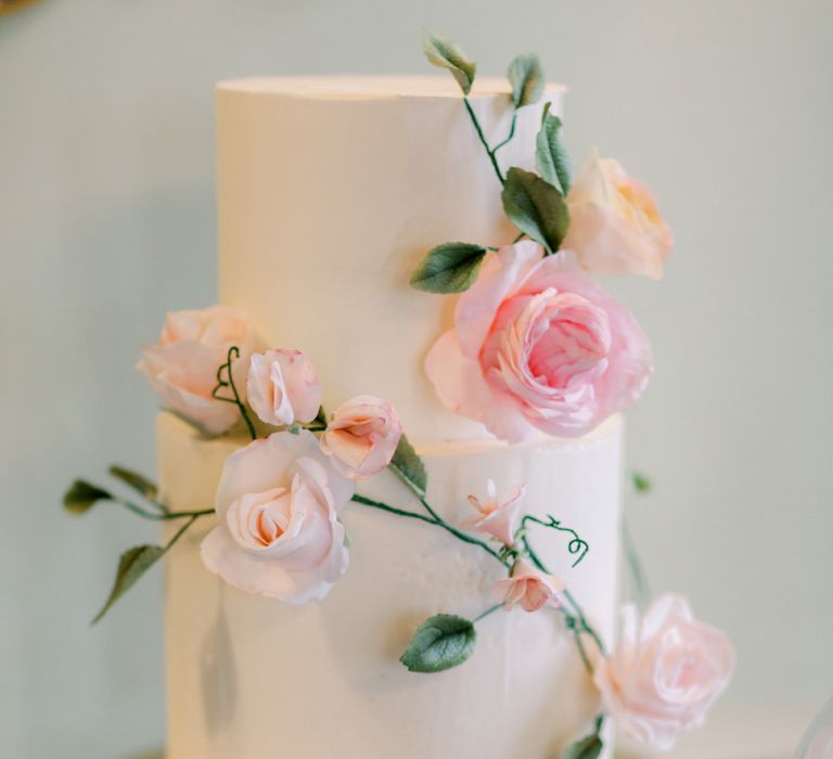 Elegant white wedding cake with pink flower decor