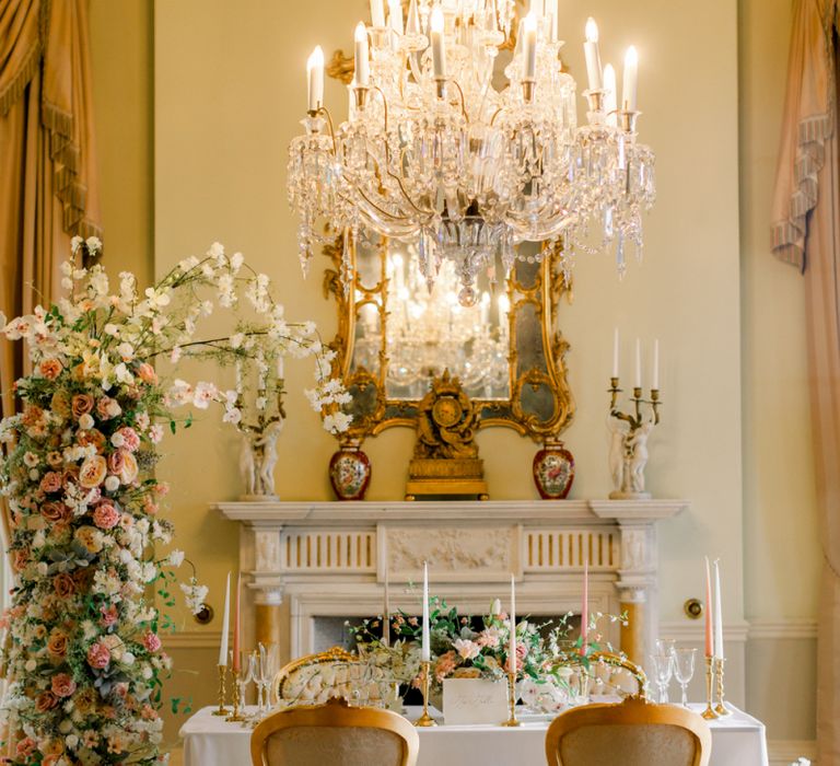 Sweetheart table at Prestwold Hall with ornate chandelier and fireplace