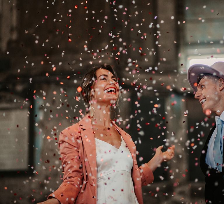 Confetti Bomb Moment with Bride in Pink Wedding Jacket and Groom in Fedora Hat