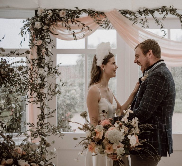 Bride Emma Beaumont Wedding Dress with Straps and Groom in Blue Check Suit Jacket Laughing at the Altar