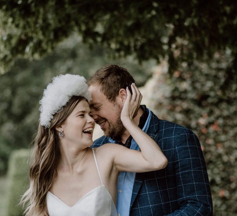 Groom in Blue Check Blazer Embracing His Bride in an Emma Beaumont Wedding Dress