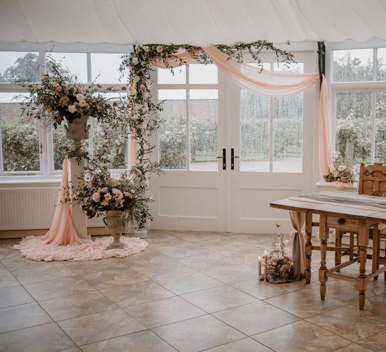 Combermere Abbey Glasshouse Ceremony Room with Draped Altar and Romantic Floral Arrangements