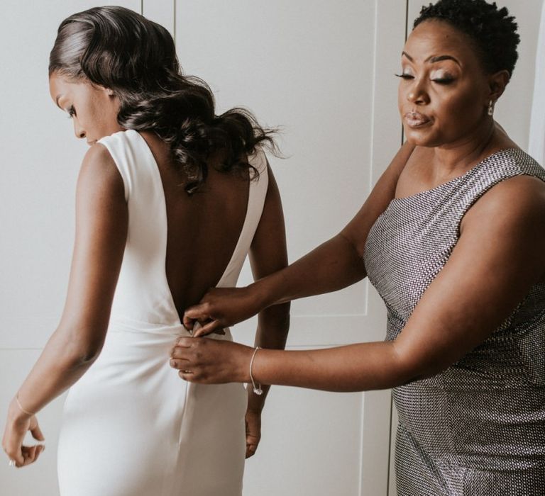 Black bride being helped into her Made With Love Bridal wedding dress