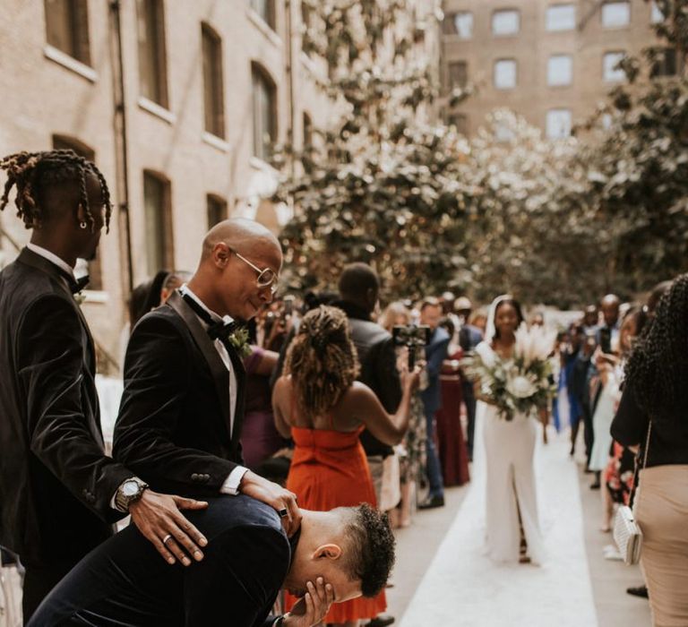 Groom collapsing to his knees as his bride walks down the aisle at Devonshire Terrace wedding ceremony