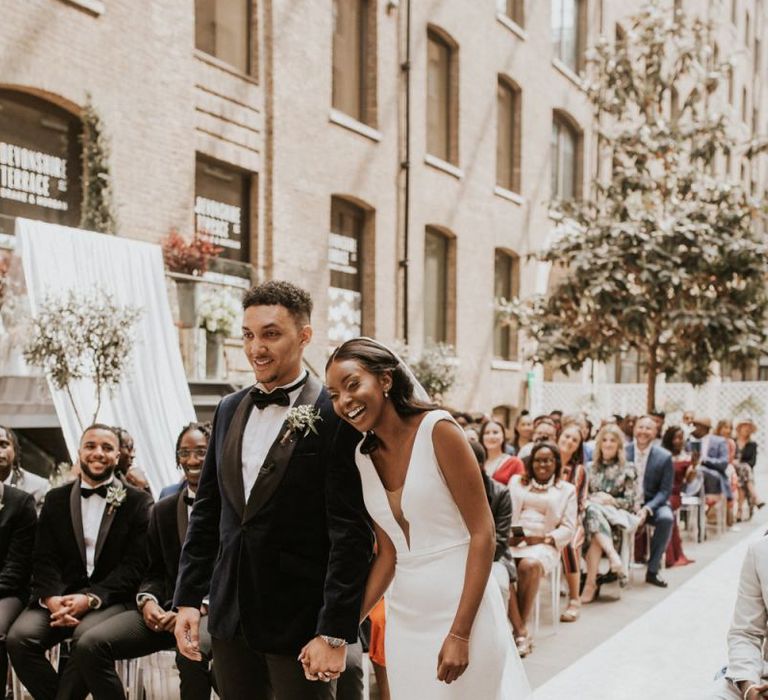 Black bride and groom laughing at the altar of their Devonshire Terrace wedding ceremony