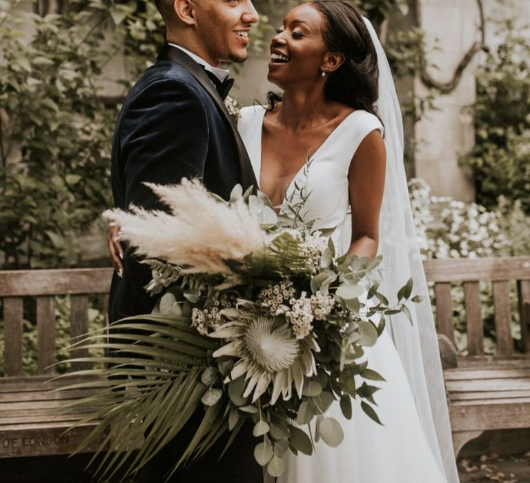 Black bride and groom wedding portrait with king protea, pampas grass and foliage bouquet