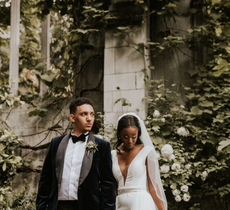 Black bride in Made With Love Bridal gown and groom in velvet dinner jacket and bow tie.