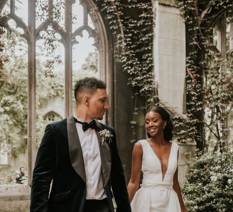 Black bride and groom holding hands at St Dunstans in the East