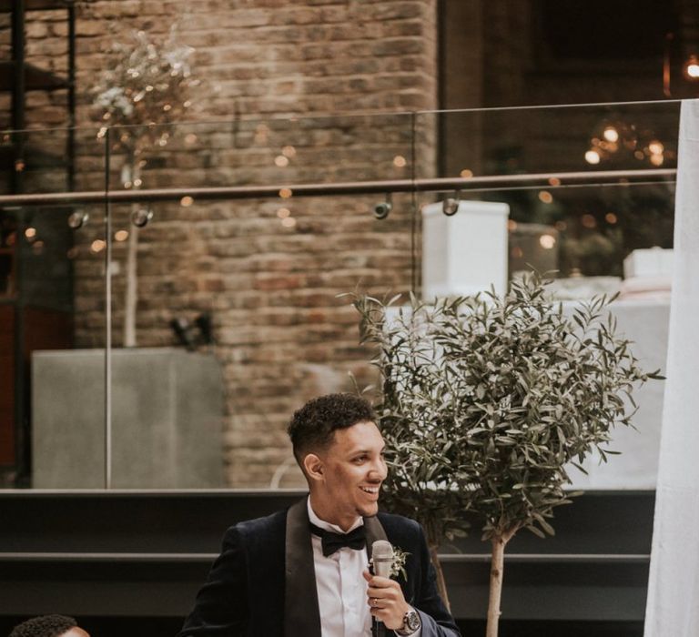 Black groom in Navy Velvet Tuxedo Jacket giving his wedding speech,