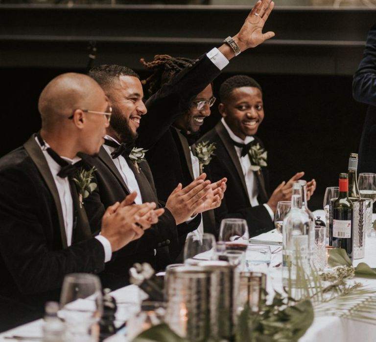 Groomsmen laughing during the wedding reception speeches.