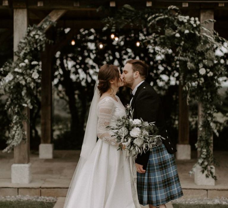 Bride and Groom Kiss At Altar