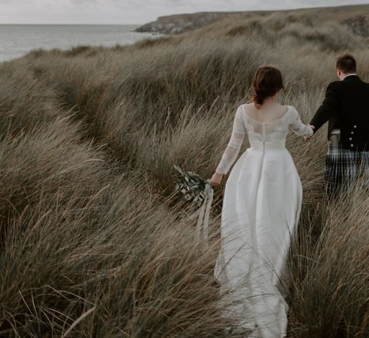 Jesus Peiro Wedding Dress With Groom In Kilt at Holywell Bay