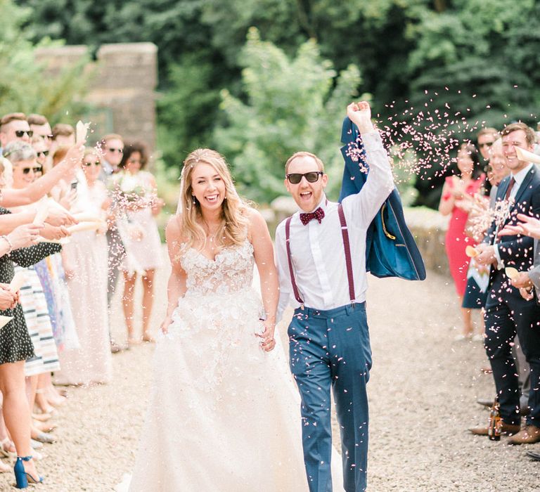 Confetti Toss | Bride in Strapless Liz Martinez Ballgown Wedding Dress with Embroidered Flowers | Groom in Navy Blue Suit with Burgundy Braces, Bow Tie and Brogues | Country Tipi Wedding with Macramé Arch and Hanging Flowers | Sarah-Jane Ethan Photography